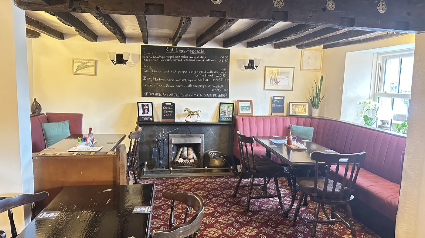 A cosy corner by the open fire, with the specials board above